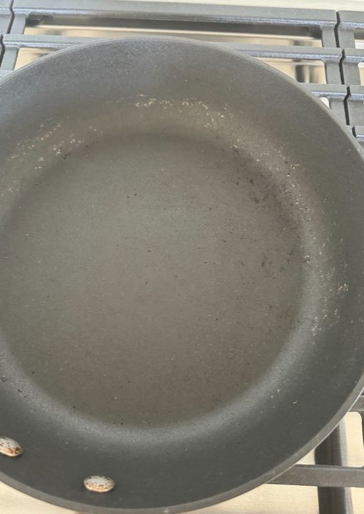 My hubby used a cast iron skillet brush on my nonstick pan. The coating looks scratched off. Is it still safe to use? He thinks so but I disagree.